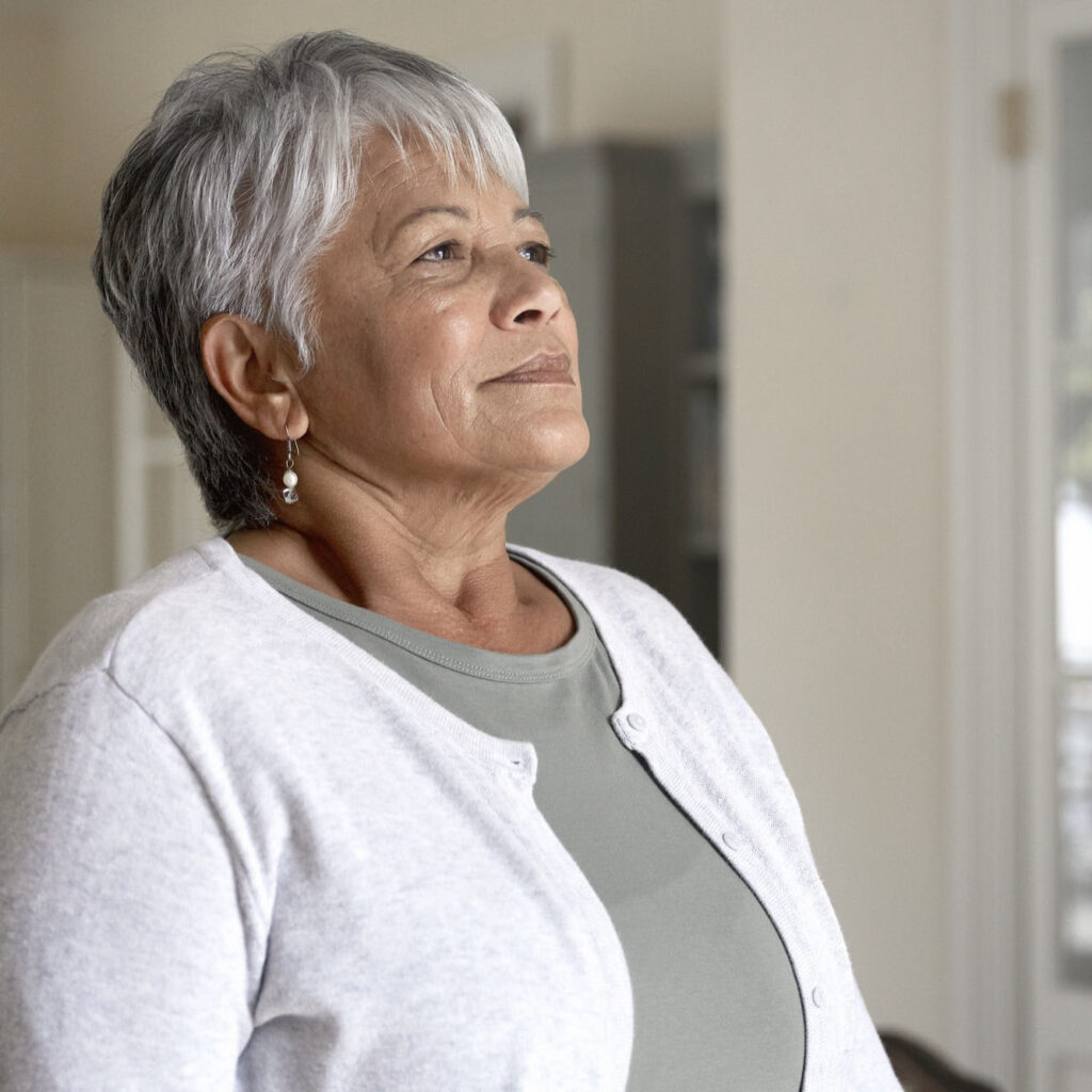 Portrait of beautiful senior woman taking a deep breath in her kitchen